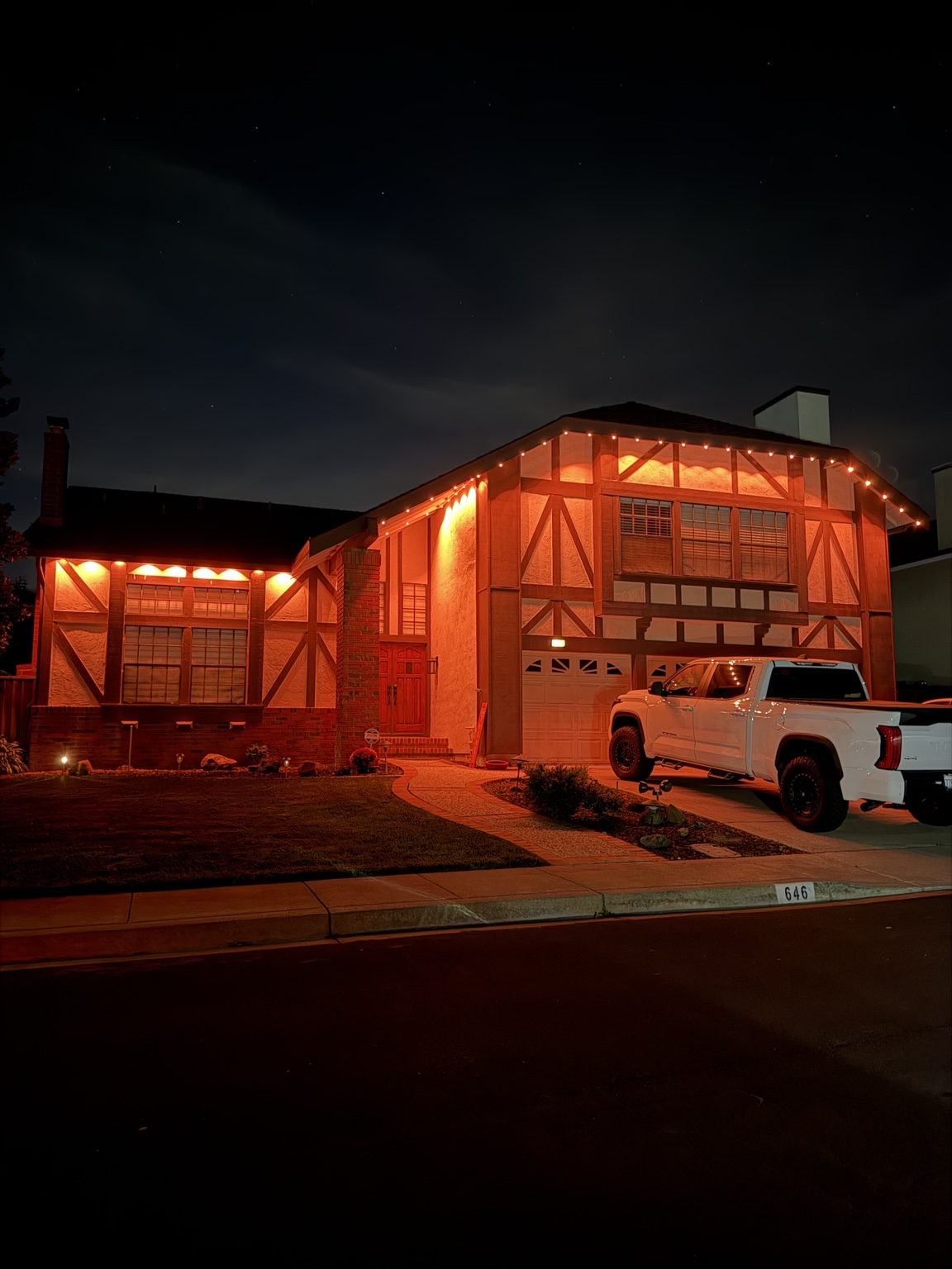 Tudor-style Bay Area home glowing in deep red permanent Govee roofline lighting