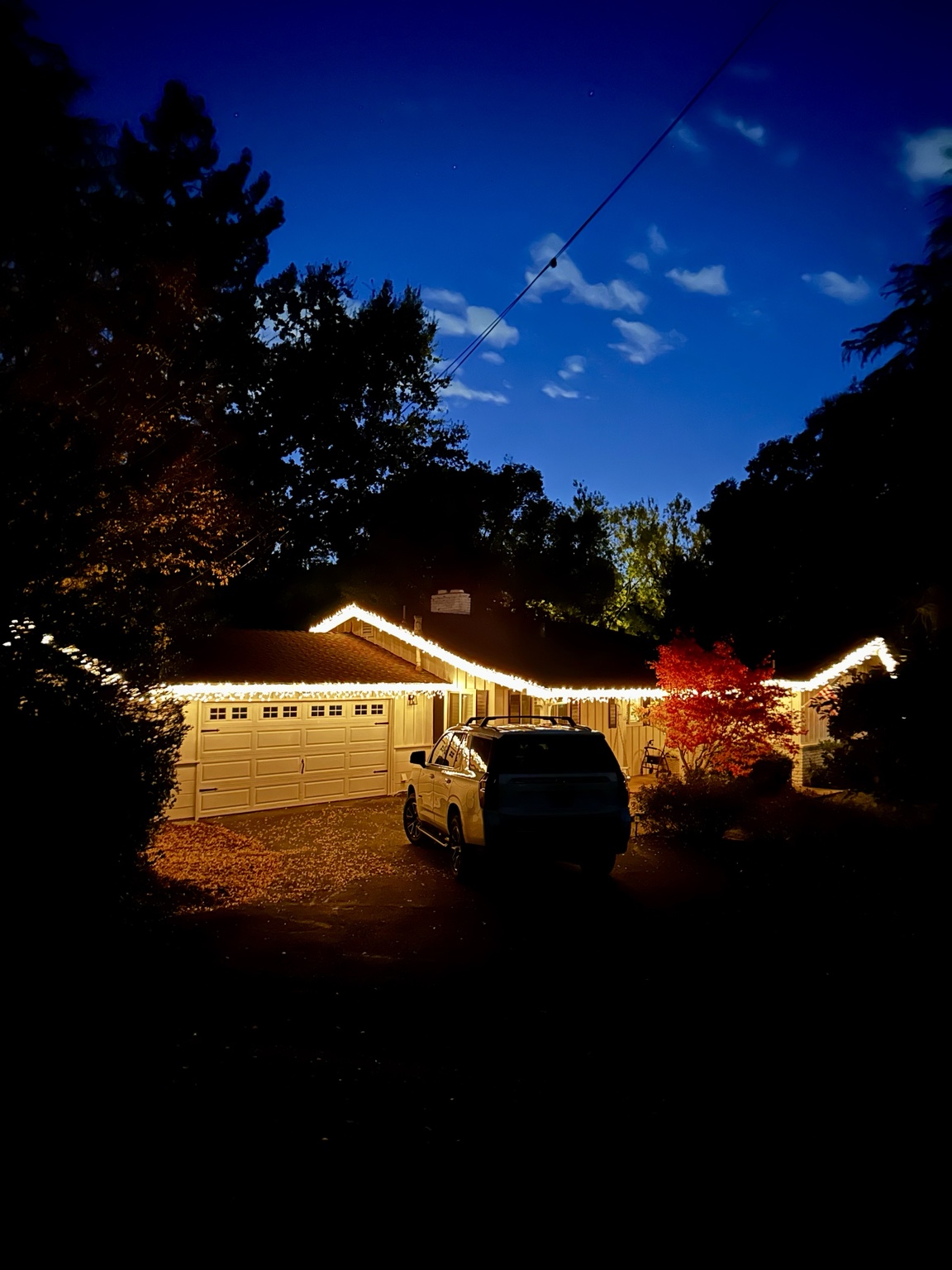 Ranch home at blue hour with warm white icicle Christmas lights along the entire roofline