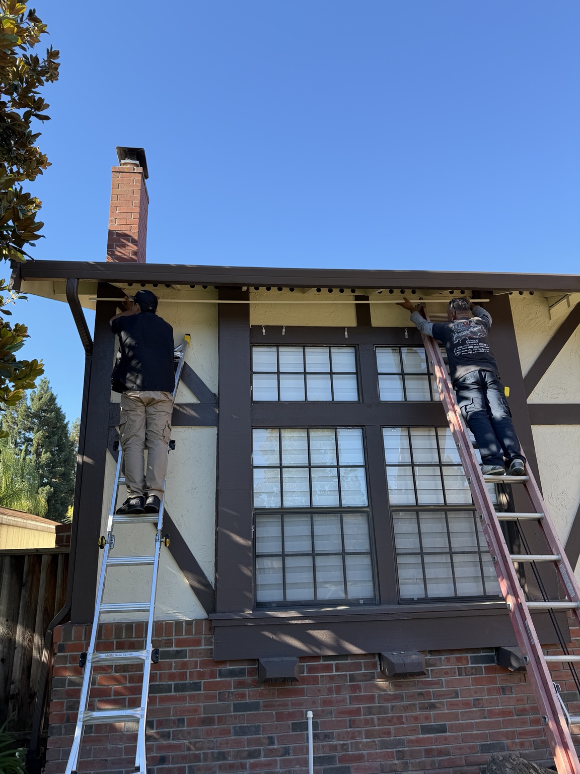 Give It Light installation crew mounting permanent lighting along a roofline
