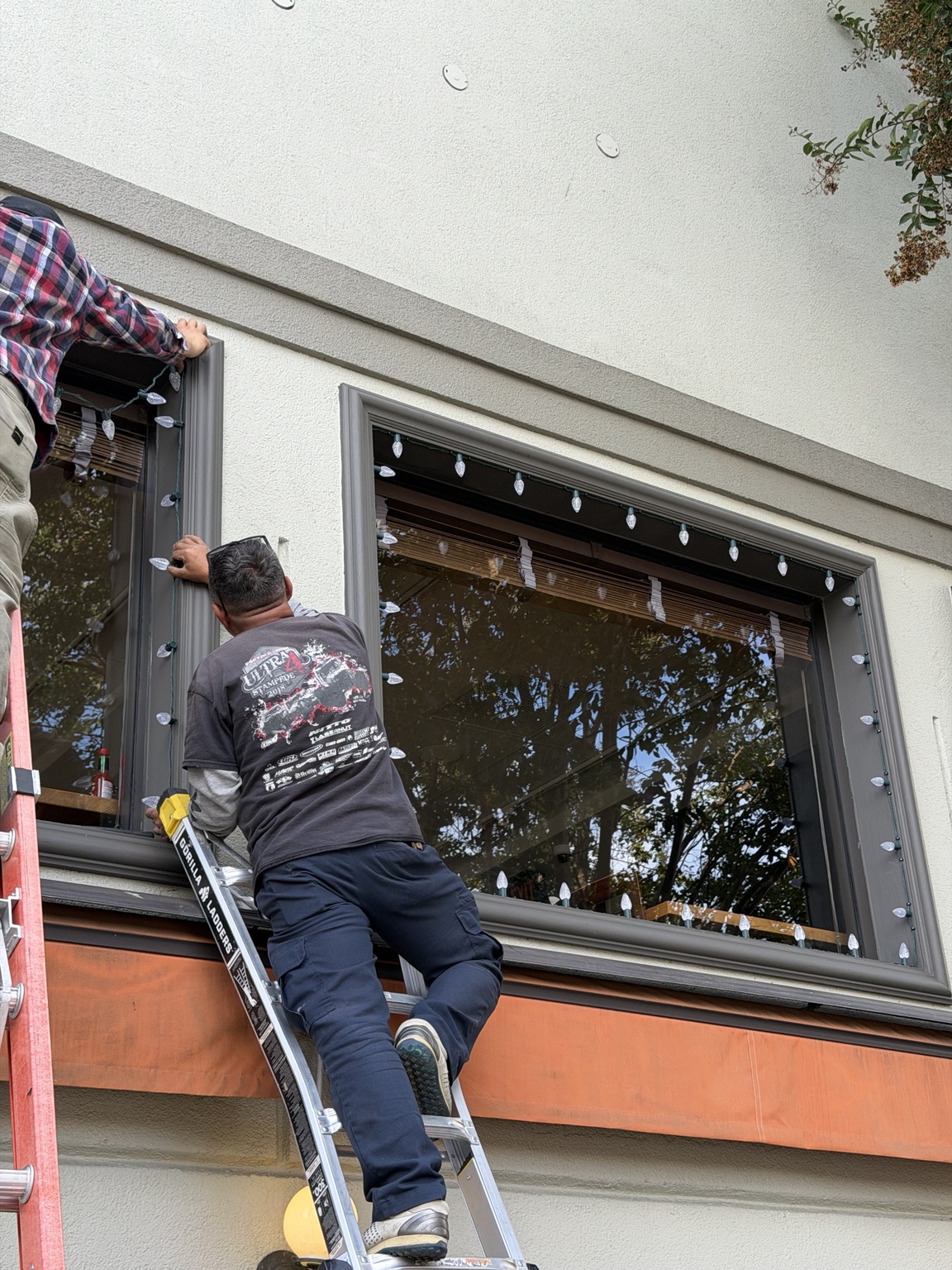Give It Light crew installing C9 holiday lights around commercial windows